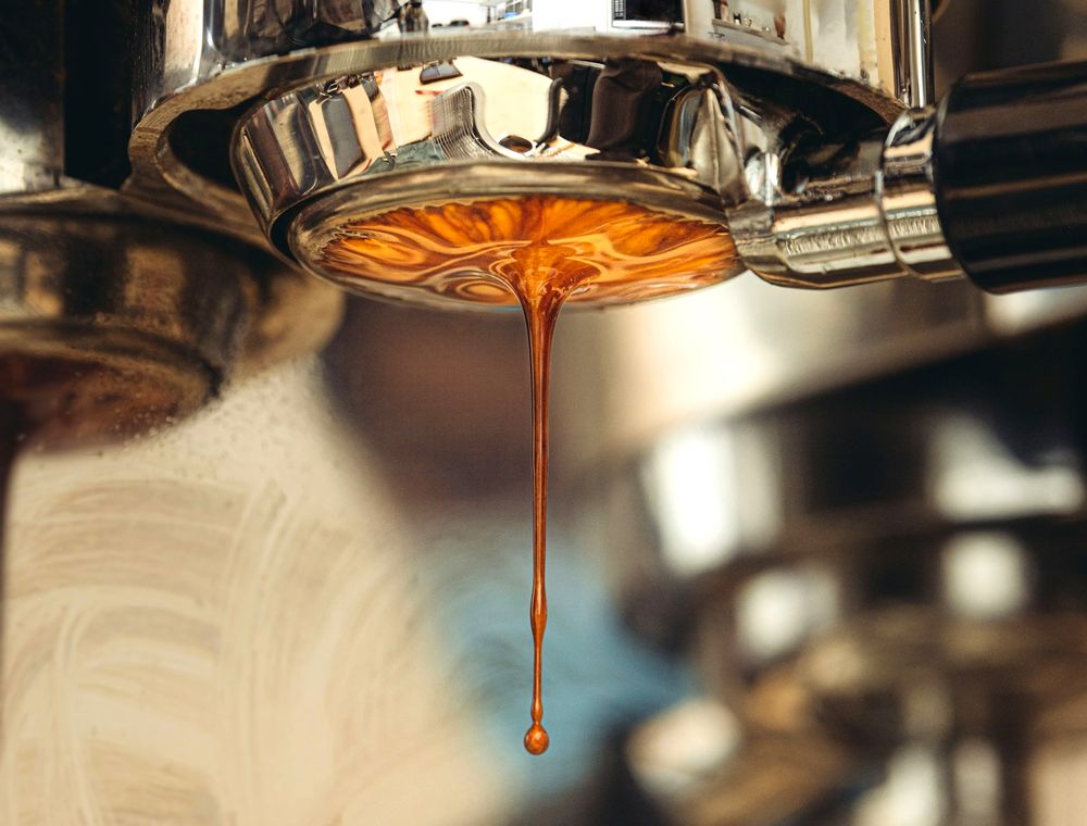 Espresso cayendo del portafiltro en una taza