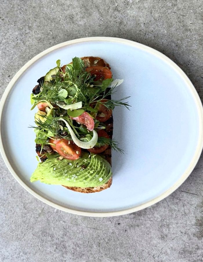 Tostada de masa madre con aguacate, tomate y hierbas